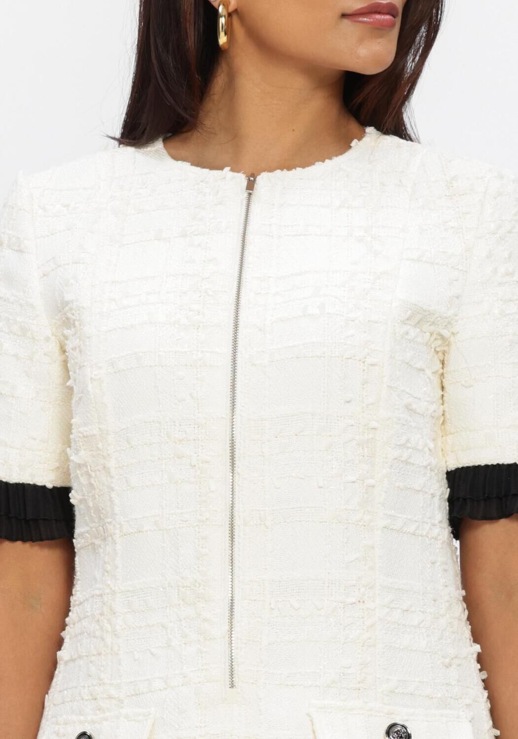 Pink Baby Colette textured zip mini dress in ivory, showing the fitted silhouette and stylish zip detail.