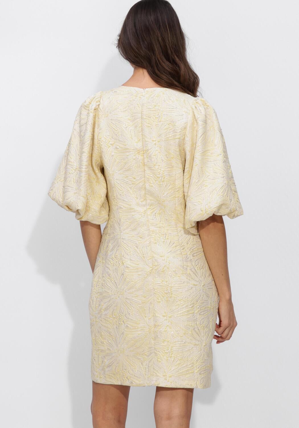 Cream Sabelle textured puff sleeve mini dress by Pink Baby, showcasing its fabric detail and stylish design on a model.