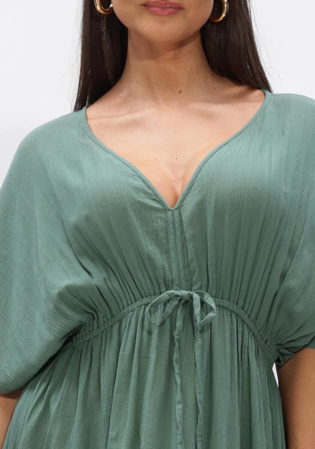Pink Baby Livia drawstring empire maxi dress in sage green, flowing fabric with a fitted waist and elegant design.