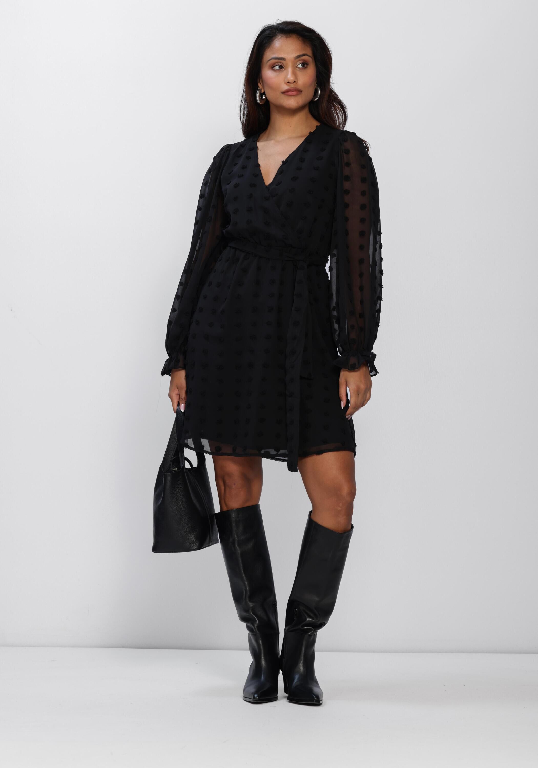 Black Emmanuelle Dobby Wrap Mini Dress by Pink Baby, with long sleeves and a fitted silhouette on a model.