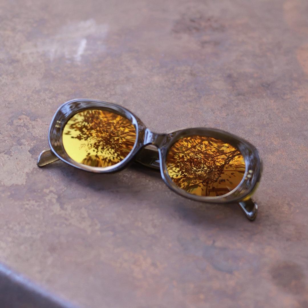 Pink Baby The Flynn olive sunglasses with round frames and dark lenses, stylish eyewear for a trendy look.
