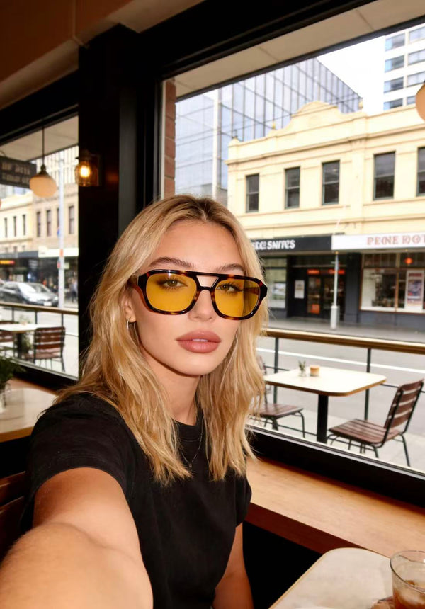 Pink Baby The Kael sunglasses with round, tinted lenses and a sleek black frame, stylish eyewear for sun protection.