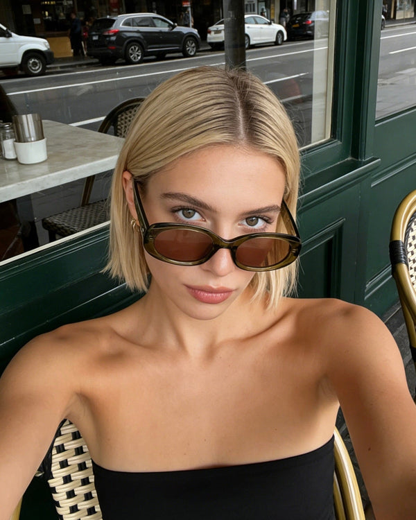 Pink Baby The Flynn olive sunglasses with round frames and tinted lenses, stylish eyewear for a trendy look.