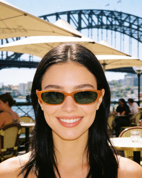 Pink Baby The Indie pumpkin-shaped sunglasses with orange tinted lenses and pink frame, stylish and fun for sunny days.