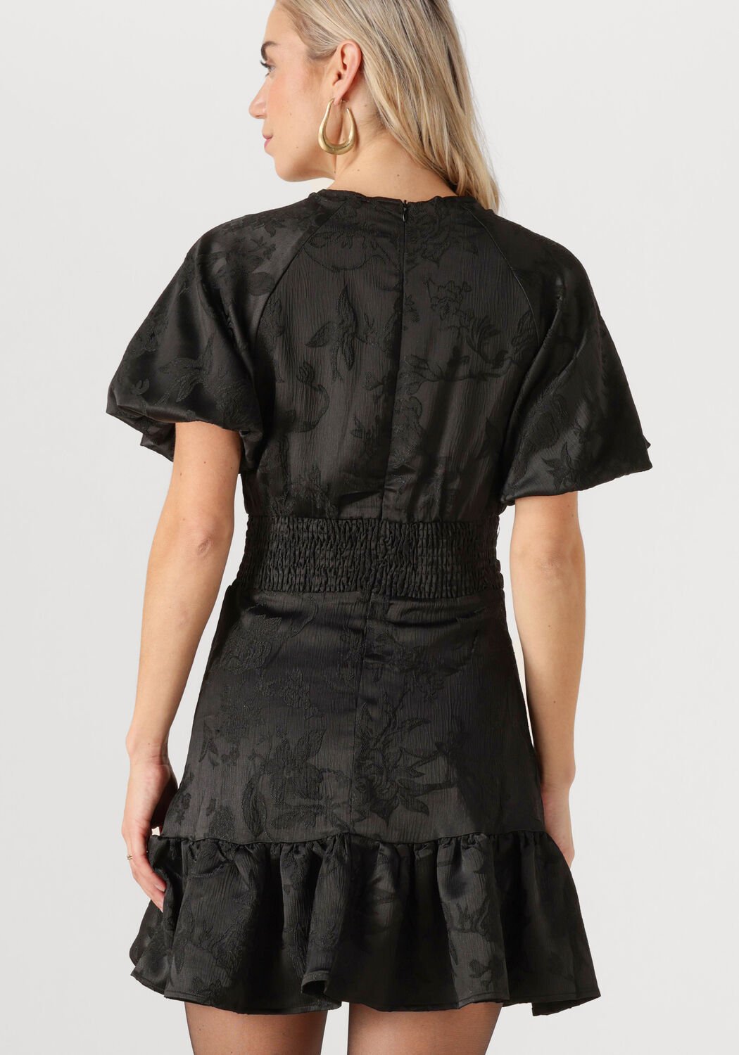 Pink Baby Celestina floral jacquard ruffle mini dress in black, featuring a stylish ruffled neckline and intricate floral pattern.