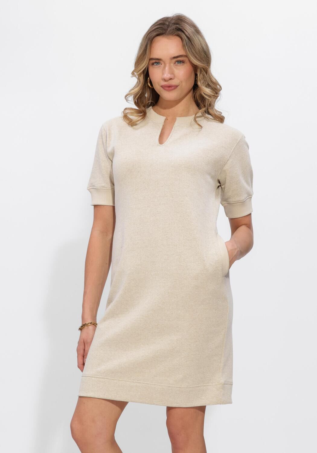 Pink Baby Elise oat beige knit mini dress with notch neckline, soft textured fabric, and fitted silhouette.