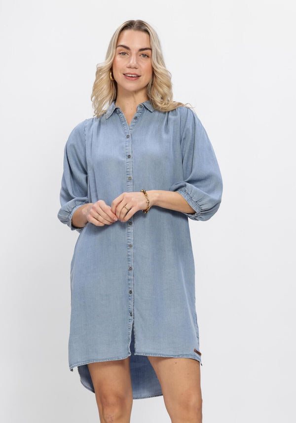 Light blue Normi button-front denim shirt dress by Pink Baby, featuring classic denim fabric and a casual, stylish fit.