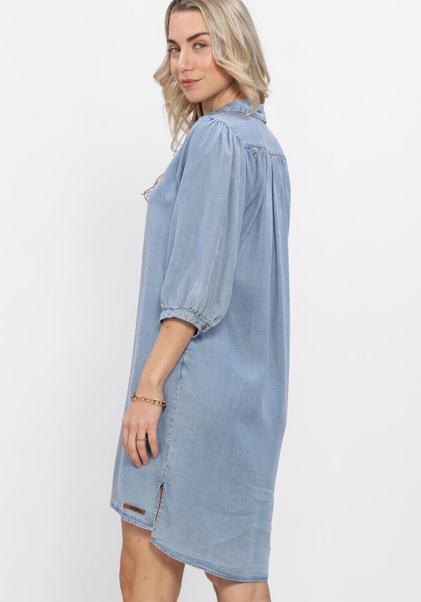Light blue Normi denim shirt dress by Pink Baby with button front and collar, casual and stylish for everyday wear.