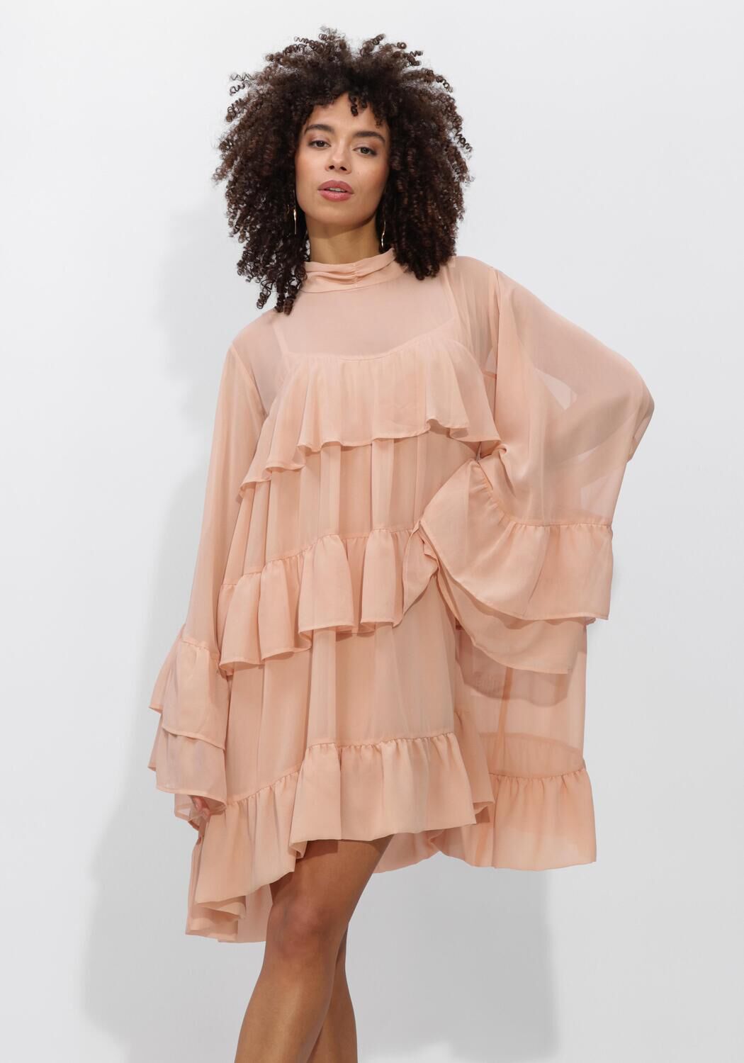 Pink Baby Celeste tiered ruffle mini dress in blush pink with layered ruffle details and sleeveless design.