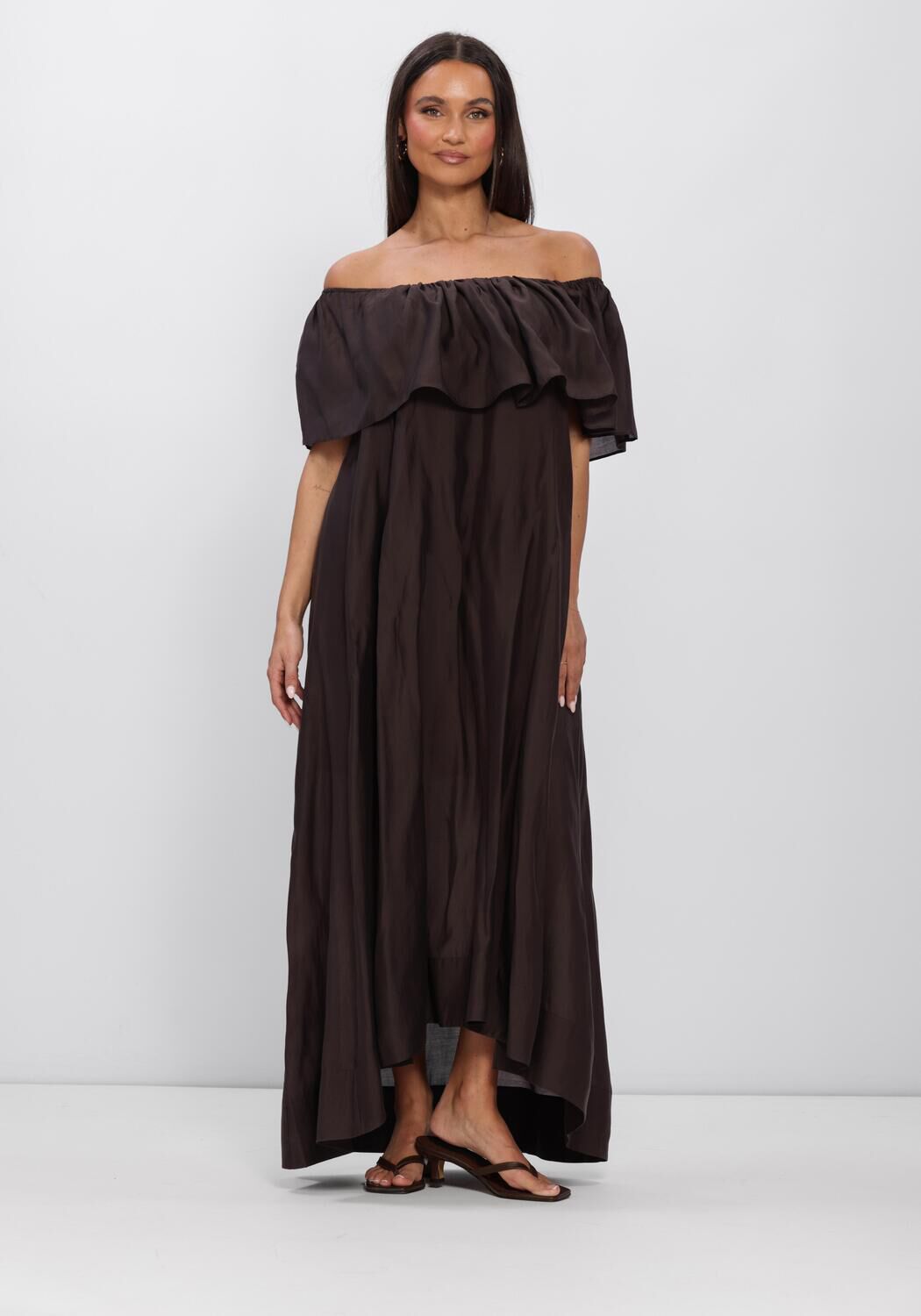 Pink Baby Serafina off-shoulder ruffle maxi dress in espresso brown, flowing fabric with ruffle details and off-shoulder design.