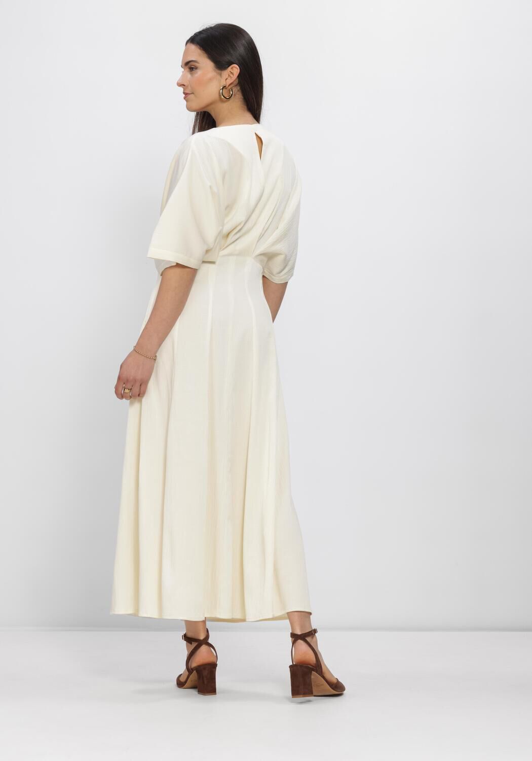 Pink Baby Valeria draped V-neck maxi dress in ivory, flowing fabric with elegant draping and a deep V neckline.