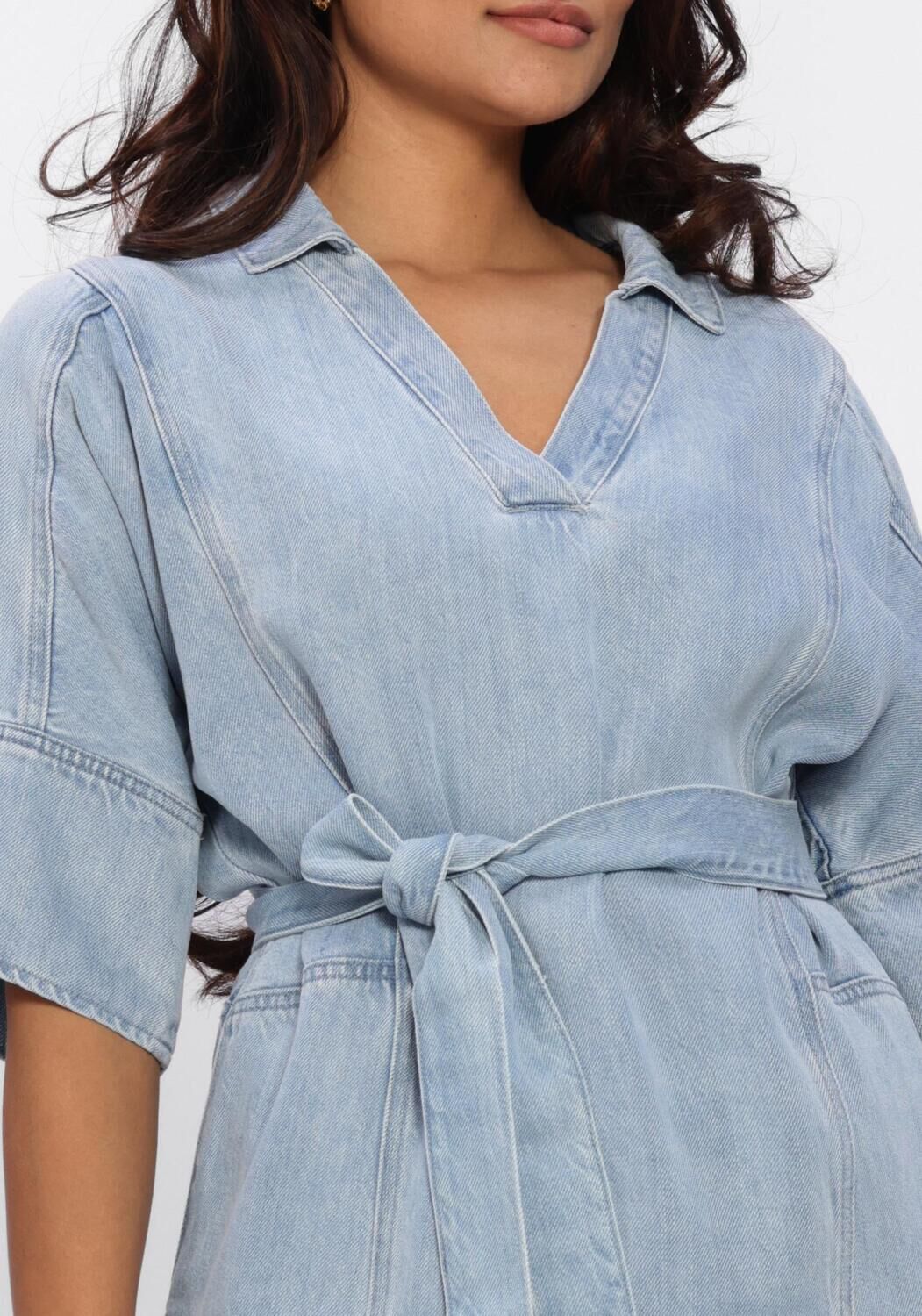 Light blue Dona belted denim mini dress by Pink Baby, featuring a fitted waist and casual style, displayed on a hanger.