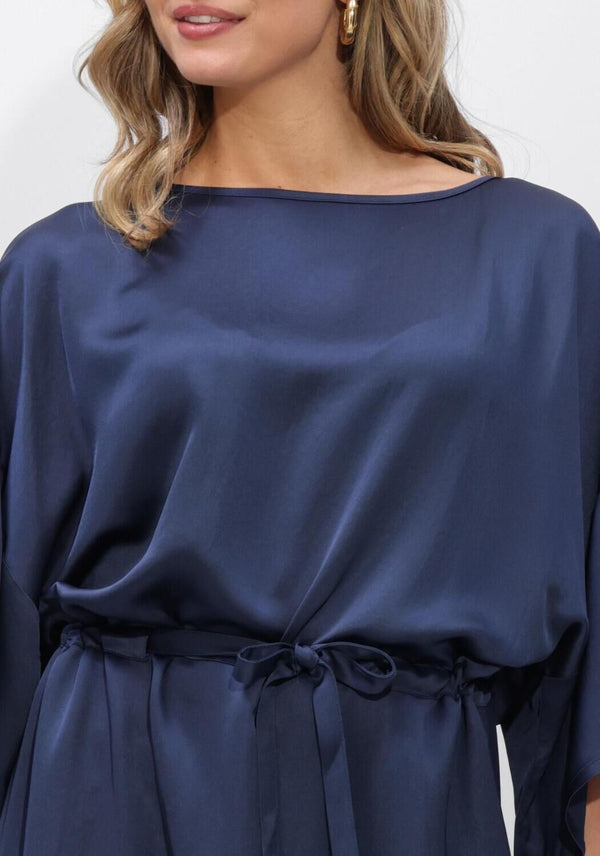 Navy Noemi satin tie-waist midi dress by Pink Baby displayed on a hanger, showcasing its elegant design and silky fabric.