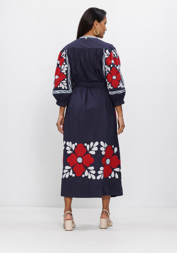 Pink Baby Elena navy floral embroidered midi dress displayed on a hanger, showcasing intricate embroidery and elegant design.