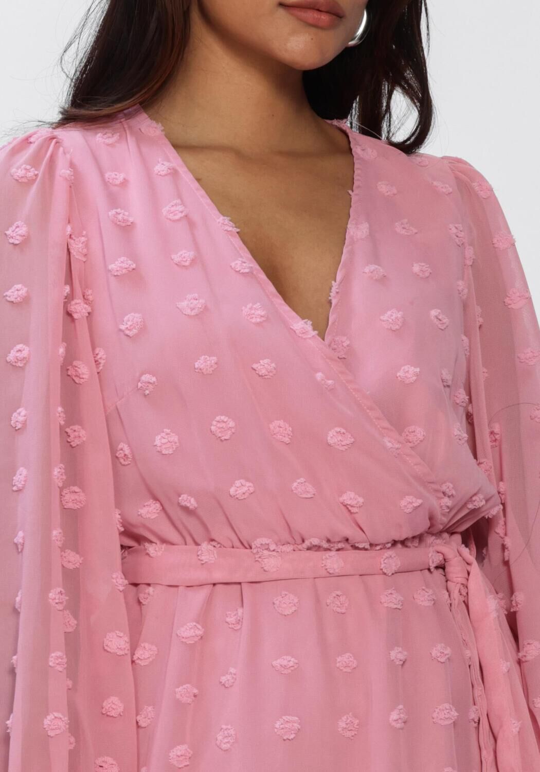 Pink Baby Rona Dobby Wrap Mini Dress in blush pink fabric, featuring a stylish wrap design and short sleeves.