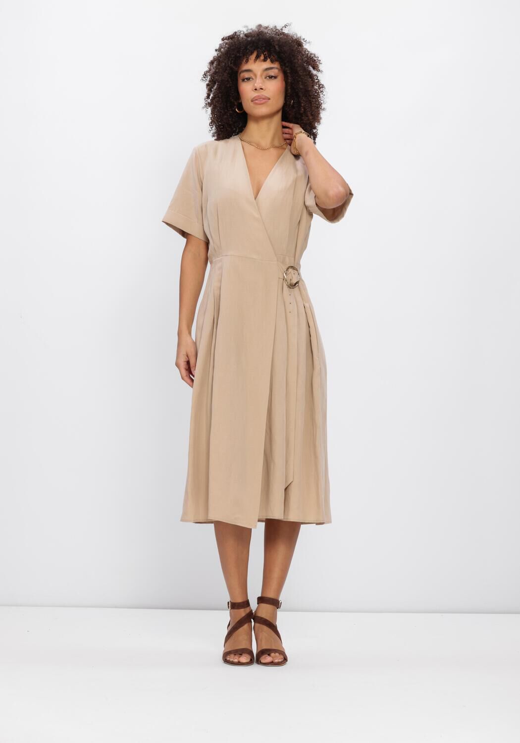 Pink Baby Camille beige buckle wrap midi dress displayed on a hanger, featuring a classic wrap design and midi length.