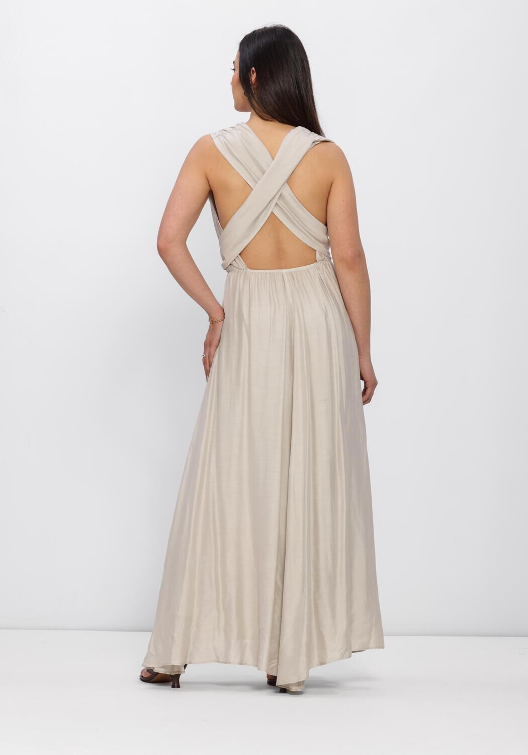 Beige Valentina pleated cross-back maxi dress by Pink Baby, showcasing flowing fabric and stylish design on a model.