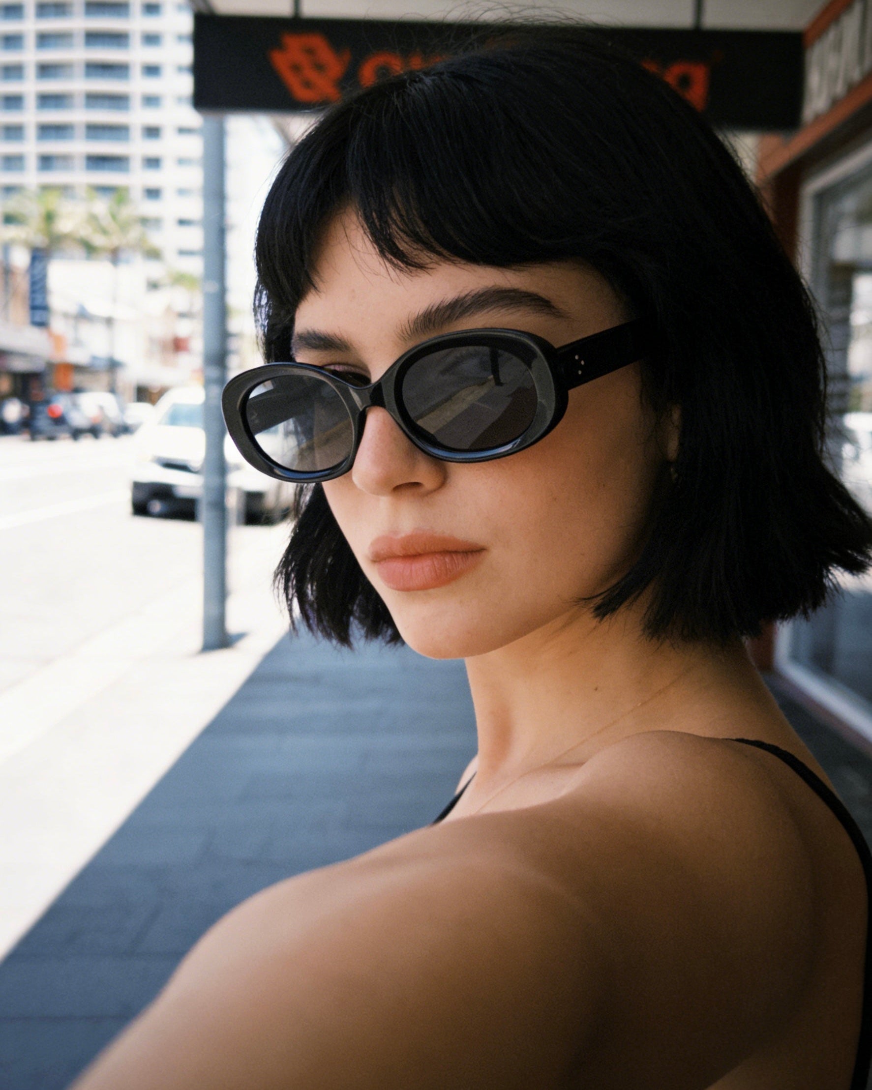 Pink Baby The Flynn black sunglasses with rounded frames and dark lenses, stylish and trendy accessory for sunny days.