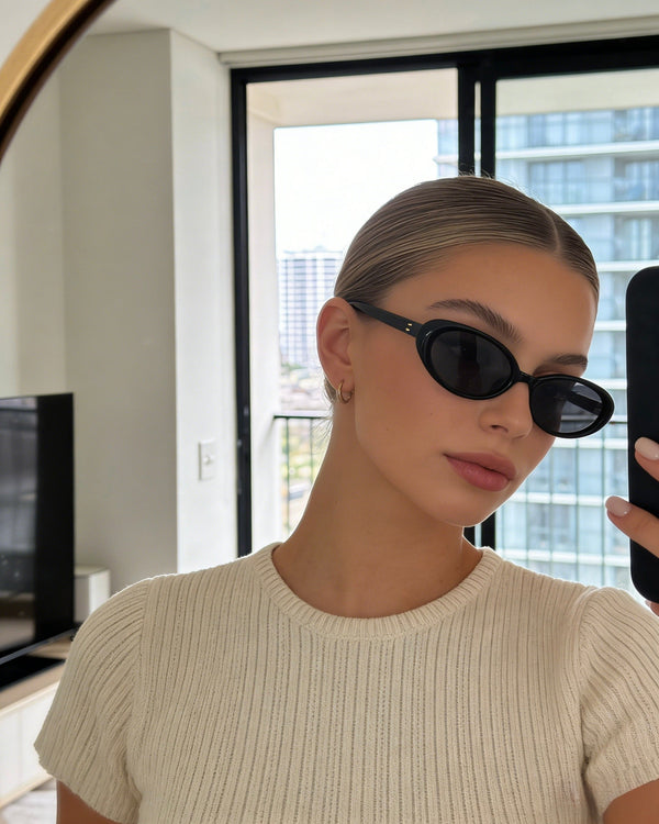 Pink Baby The Kyra black sunglasses with rounded frames and dark lenses, stylish and protective eyewear for women.
