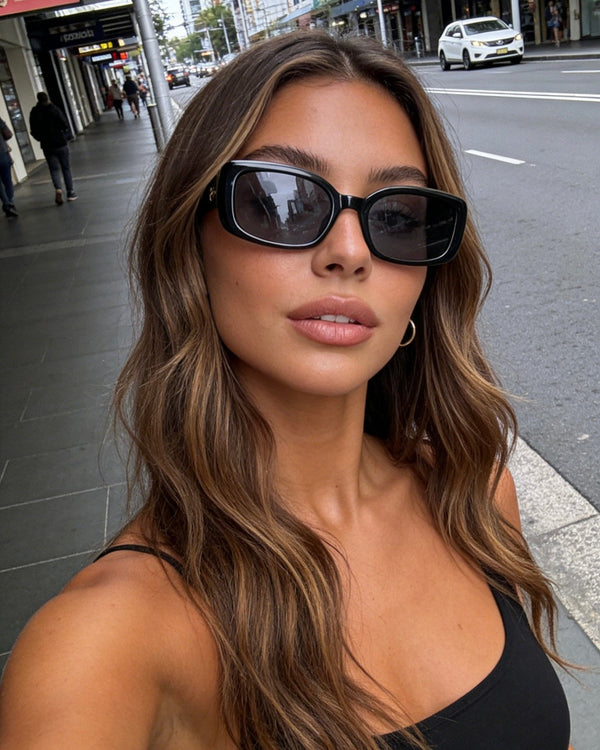 Pink Baby The Fern black sunglasses with sleek frames and dark lenses, stylish accessory for sunny days.