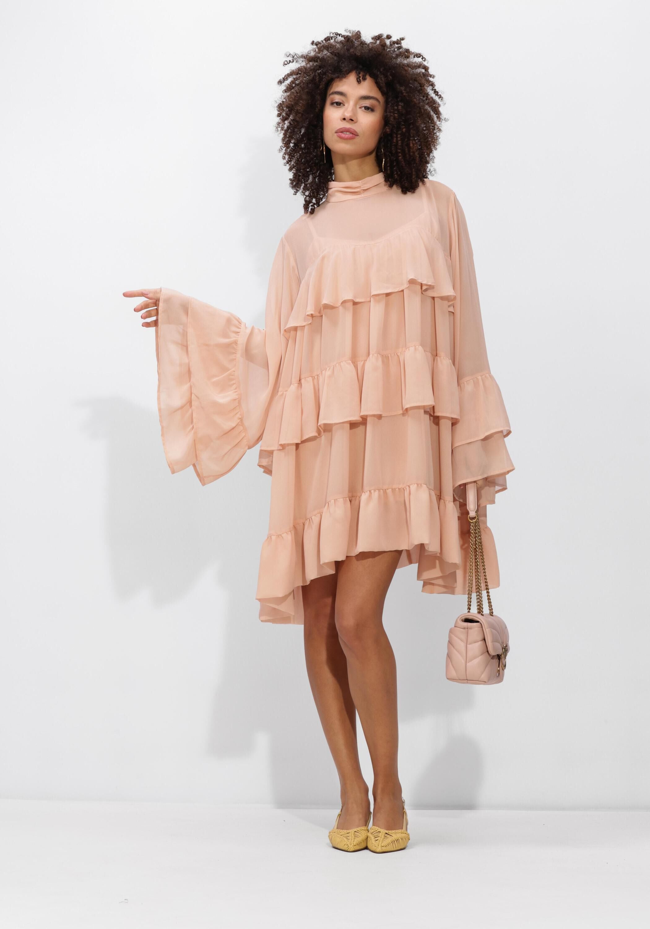 Pink Baby Celeste Tiered Ruffle Mini Dress in blush pink, featuring layered ruffles and a short, flared design.
