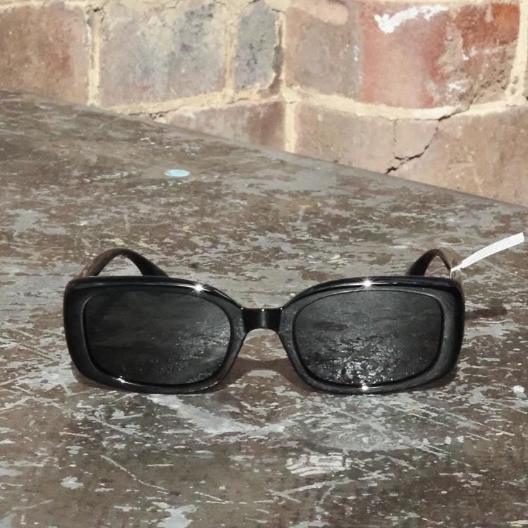 Pink Baby The Fern black sunglasses with sleek frame and dark lenses, stylish accessory for sun protection and fashion.