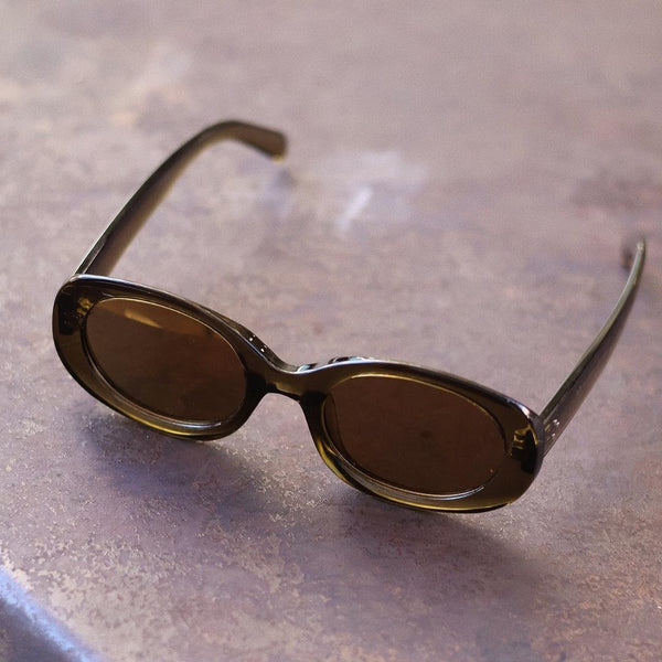 Pink Baby The Flynn olive sunglasses with round frames and dark lenses, stylish eyewear for a trendy look.