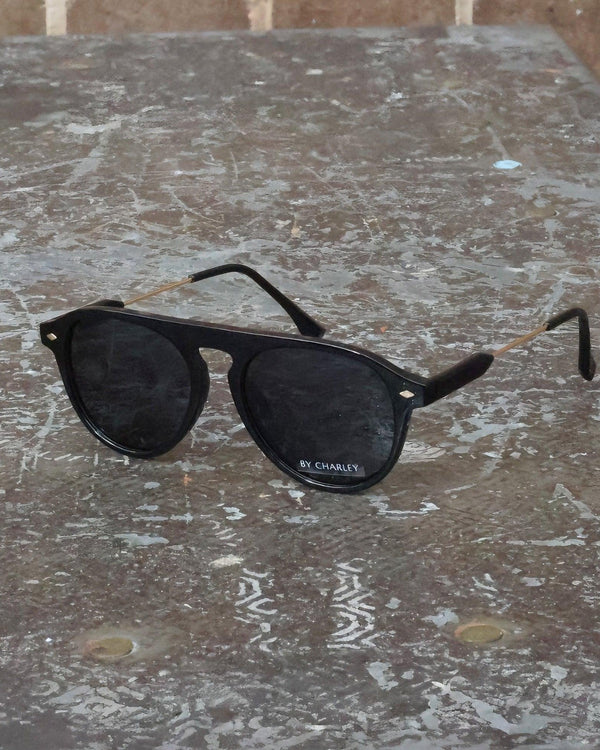 Pink Baby The Riley black sunglasses with rounded frames and dark lenses, stylish eyewear for a fashionable look.