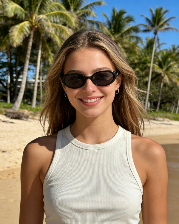 Black Pink Baby Kyra sunglasses with dark tinted lenses and stylish frame, shown on a white background.