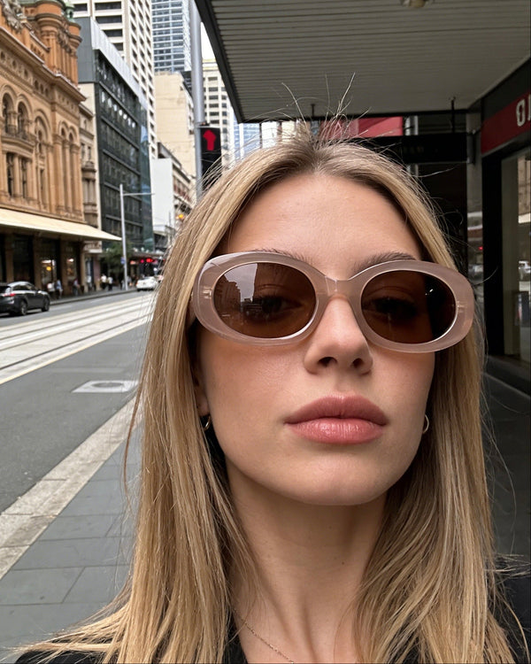 Pink Baby Flynn sunglasses with pink frames and dark tinted lenses, styled with a fashionable and playful design.