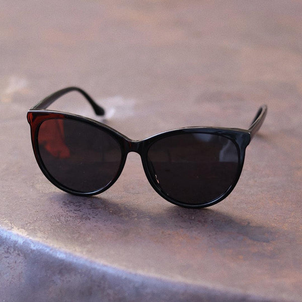 Pink Baby The Yule black sunglasses with rounded frames and dark lenses, stylish eyewear for a trendy look.